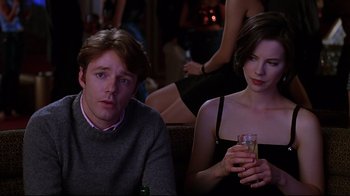 Movie still from “The Last Days of Disco” (1998), directed by Whit Stillman – A man and a woman sitting next to each other at a party; Medium shot, Over the shoulder angle