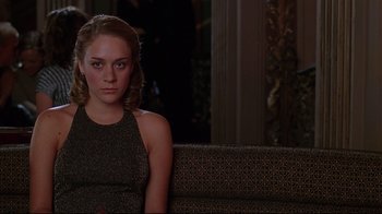 Movie still from “The Last Days of Disco” (1998), directed by Whit Stillman – A woman sitting on top of a couch in front of a mirror; Close Up shot, Over the shoulder angle