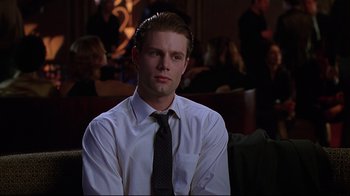 Movie still from “The Last Days of Disco” (1998), directed by Whit Stillman – A man in a white dress shirt and a black tie; Close Up shot, Over the shoulder angle