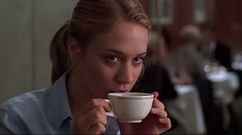 Movie still from “The Last Days of Disco” (1998), directed by Whit Stillman – A beautiful young lady holding a cup of coffee; Close Up shot, Low angle