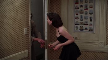 Movie still from “The Last Days of Disco” (1998), directed by Whit Stillman – A woman in a black dress looking in a mirror; Medium shot, Over the shoulder angle