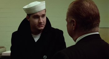 Movie still from “The Last Detail” (1973), directed by Hal Ashby – A man wearing a sailor's uniform talking to another man; Close Up shot, Over the shoulder angle