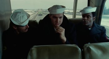 Movie still from “The Last Detail” (1973), directed by Hal Ashby – A group of people sitting on a bus looking out the window; Medium shot, High angle