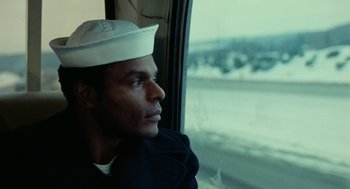 Movie still from “The Last Detail” (1973), directed by Hal Ashby – A man wearing a hat looking out of a window; Close Up shot, Low angle