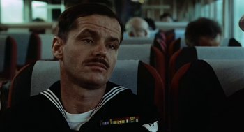 Movie still from “The Last Detail” (1973), directed by Hal Ashby – A man with a mustache sitting on a train; Close Up shot, Low angle