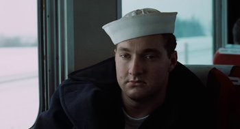 Movie still from “The Last Detail” (1973), directed by Hal Ashby – A man wearing a sailor's hat sitting in front of a window; Close Up shot, Low angle