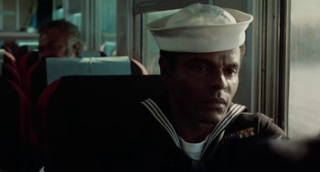 Movie still from “The Last Detail” (1973), directed by Hal Ashby – A man wearing a sailor's hat sitting on a bus; Close Up shot, Over the shoulder angle