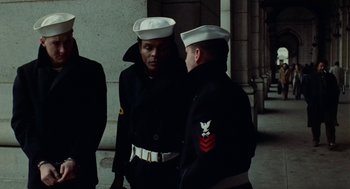 Movie still from “The Last Detail” (1973), directed by Hal Ashby – Two men dressed in navy uniforms talking to each other; Medium shot, Low angle