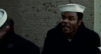 Movie still from “The Last Detail” (1973), directed by Hal Ashby – A man wearing a sailor's hat in front of a brick wall; Close Up shot, Low angle