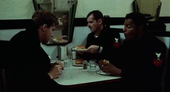 Movie still from “The Last Detail” (1973), directed by Hal Ashby – A group of men sitting at a table with plates of food; Medium shot, Over the shoulder angle