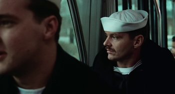 Movie still from “The Last Detail” (1973), directed by Hal Ashby – A man in a white hat looking out a window; Close Up shot, Over the shoulder angle
