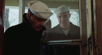 Movie still from “The Last Detail” (1973), directed by Hal Ashby – A man in a sailor's uniform looking at a man in a sailor's uniform; Medium shot, Low angle