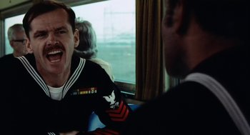 Movie still from “The Last Detail” (1973), directed by Hal Ashby – A man in a uniform is sitting next to another man; Close Up shot, Over the shoulder angle