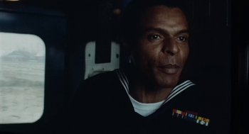 Movie still from “The Last Detail” (1973), directed by Hal Ashby – A man in a navy uniform sitting in front of a guitar; Close Up shot, Low angle