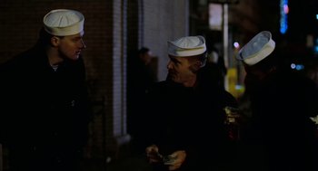 Movie still from “The Last Detail” (1973), directed by Hal Ashby – A group of people standing next to each other on a street; Medium shot, Over the shoulder angle