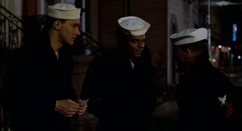 Movie still from “The Last Detail” (1973), directed by Hal Ashby – A group of men standing next to each other on a street; Medium shot, High angle