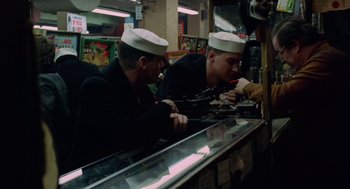 Movie still from “The Last Detail” (1973), directed by Hal Ashby – Two men in navy uniforms are eating at a counter; Medium shot, High angle