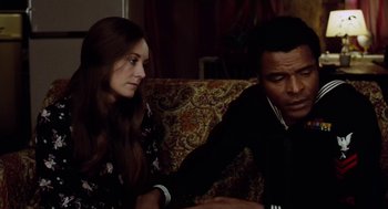 Movie still from “The Last Detail” (1973), directed by Hal Ashby – A man and a woman sitting on a couch looking at each other; Close Up shot, High angle