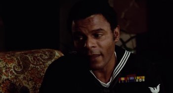 Movie still from “The Last Detail” (1973), directed by Hal Ashby – A person sitting on a couch; Close Up shot, Over the shoulder angle