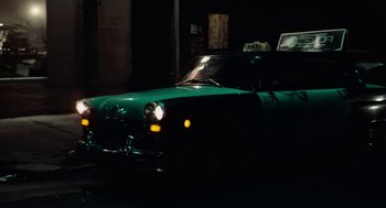 Movie still from “The Last Detail” (1973), directed by Hal Ashby – A green taxi cab driving down a street at night; Wide shot, High angle
