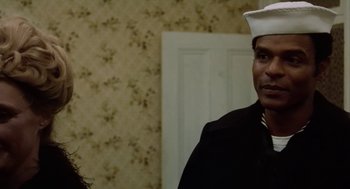 Movie still from “The Last Detail” (1973), directed by Hal Ashby – A man in a sailor's uniform standing next to a woman in front of a door; Close Up shot, Over the shoulder angle