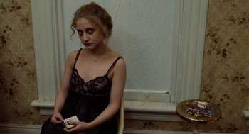 Movie still from “The Last Detail” (1973), directed by Hal Ashby – A woman in a black dress is holding a box; Medium shot, Over the shoulder angle
