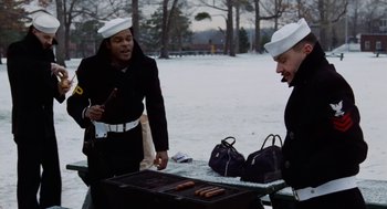 Movie still from “The Last Detail” (1973), directed by Hal Ashby – Two men wearing hats and eating hotdogs on a grill; Medium shot, Over the shoulder angle