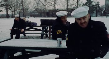 Movie still from “The Last Detail” (1973), directed by Hal Ashby – Two men sitting at a picnic table in the snow; Medium shot, Over the shoulder angle