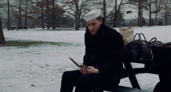 Movie still from “The Last Detail” (1973), directed by Hal Ashby – A man sitting on top of a park bench; Medium shot, Low angle