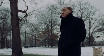 Movie still from “The Last Detail” (1973), directed by Hal Ashby – A man in a sailor's uniform walking in the snow; Medium shot, Low angle