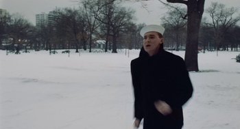 Movie still from “The Last Detail” (1973), directed by Hal Ashby – A man wearing a sailor's hat walking through the snow; Medium shot, Low angle