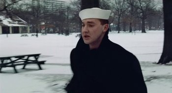 Movie still from “The Last Detail” (1973), directed by Hal Ashby – A man wearing a sailor's hat walking in the snow; Close Up shot, High angle