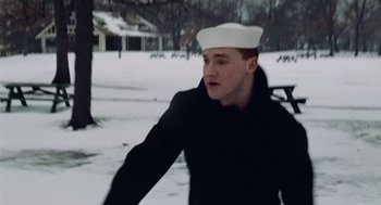 Movie still from “The Last Detail” (1973), directed by Hal Ashby – A man wearing a sailor's hat while standing in the snow; Medium shot, Low angle