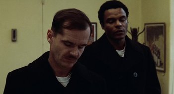 Movie still from “The Last Detail” (1973), directed by Hal Ashby – Two men in black shirts and white t - shirts are praying; Close Up shot, Low angle