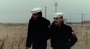 Movie still from “The Last Detail” (1973), directed by Hal Ashby – Two men in white hats are walking on a dirt road; Medium shot, Low angle
