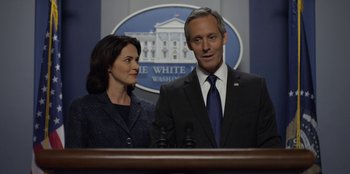 Movie still from “House of Cards” (2013), created by Beau Willimon – A man and a woman standing in front of microphones in front of the white house; Close Up shot, Over the shoulder angle