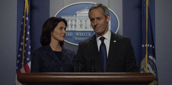 Movie still from “House of Cards” (2013), created by Beau Willimon – A man and a woman standing in front of microphones in front of the white house; Close Up shot, Over the shoulder angle