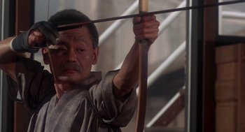 A man holding a bow and arrow in a room