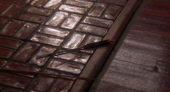 Movie still from “The Last Dragon” (1985), directed by Michael Schultz – View of a brick floor with a knife; Extreme Close Up shot, Overhead angle