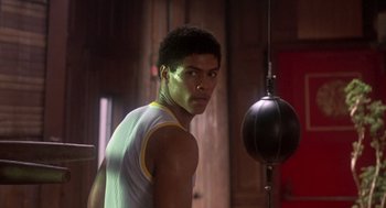 Movie still from “The Last Dragon” (1985), directed by Michael Schultz – A young man is standing in front of a punching bag; Medium shot, Low angle