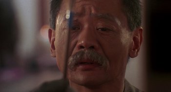 Movie still from “The Last Dragon” (1985), directed by Michael Schultz – An older man with a mustache is looking at the camera; Close Up shot, Over the shoulder angle