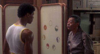 Movie still from “The Last Dragon” (1985), directed by Michael Schultz – A man and a young boy standing next to each other in front of a mirror; Medium shot, Over the shoulder angle