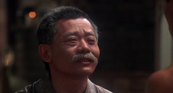 Movie still from “The Last Dragon” (1985), directed by Michael Schultz – An older man with a mustache is looking up; Close Up shot, Low angle
