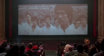 Movie still from “The Last Dragon” (1985), directed by Michael Schultz – A group of people sitting in front of a movie screen; Wide shot, High angle