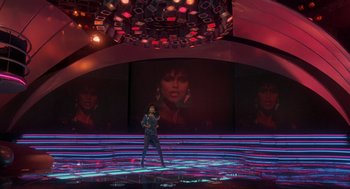 Movie still from “The Last Dragon” (1985), directed by Michael Schultz – A woman standing in front of a stage with lights; Extreme Wide shot, High angle