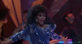 Movie still from “The Last Dragon” (1985), directed by Michael Schultz – A woman in a blue dress is singing; Medium shot, Low angle