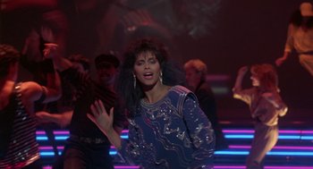 Movie still from “The Last Dragon” (1985), directed by Michael Schultz – A woman in a blue dress is dancing in a nightclub; Medium shot, Over the shoulder angle