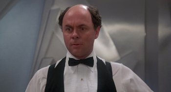 Movie still from “The Last Dragon” (1985), directed by Michael Schultz – A bald man in a white shirt and a black bow tie; Close Up shot, Low angle