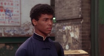 Movie still from “The Last Dragon” (1985), directed by Michael Schultz – A young man in a blue shirt is looking at the camera; Close Up shot, Over the shoulder angle