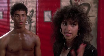 Movie still from “The Last Dragon” (1985), directed by Michael Schultz – A man and a woman standing next to each other in a room; Close Up shot, Over the shoulder angle